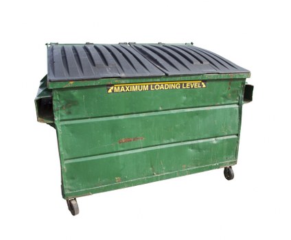 A large, industrial green waste disposal skip with a black, ridged metal lid, situated outdoors on a paved surface, likely in a commercial or construction environment. The skip features a yellow label indicating the maximum loading level near the top front edge, and small caster wheels at the base for mobility. The surface of the skip shows signs of use, including minor scratches and wear marks. In the background, there is a blurred outdoor setting, suggesting an open area suitable for rubbish collection and disposal services. This image exemplifies typical equipment used by Commercial Waste Potters Bar for rubbish removal in the local area, emphasizing practical waste management solutions.